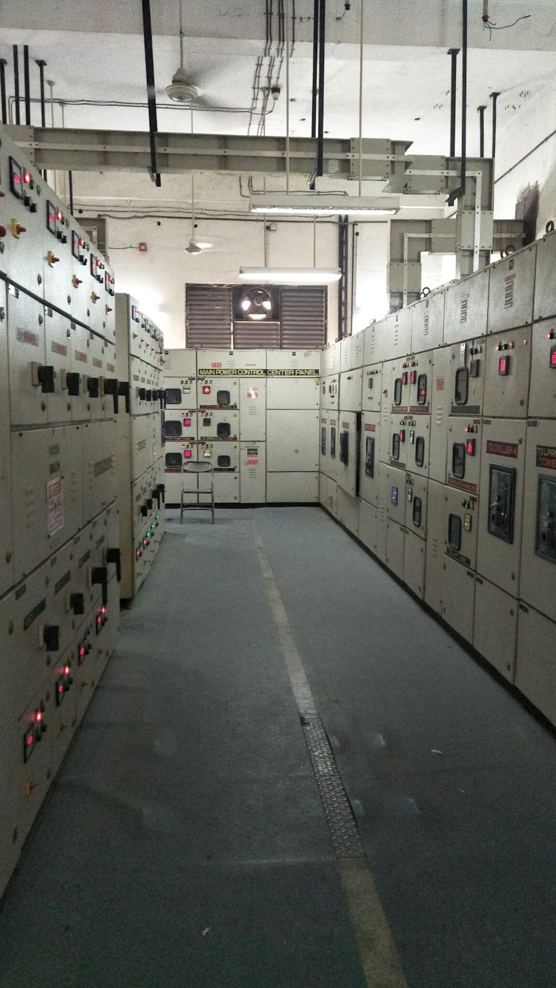 Corridoio industriale con quadri elettrici e centro di potenza principale.